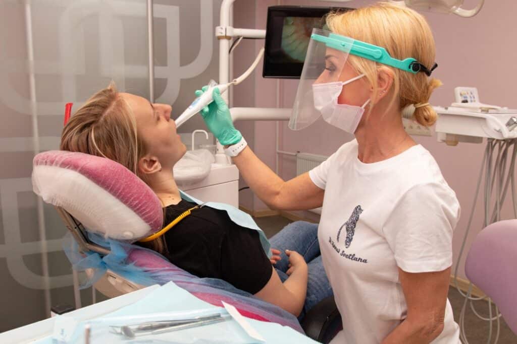 A dentist in Columbus, GA is cleaning a woman's teeth. and preparing her for dental crown