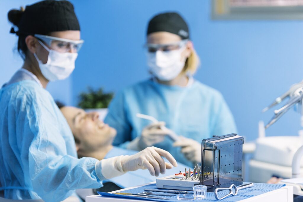 A family dentist removing a tooth from a patient's mouth using specialized tools