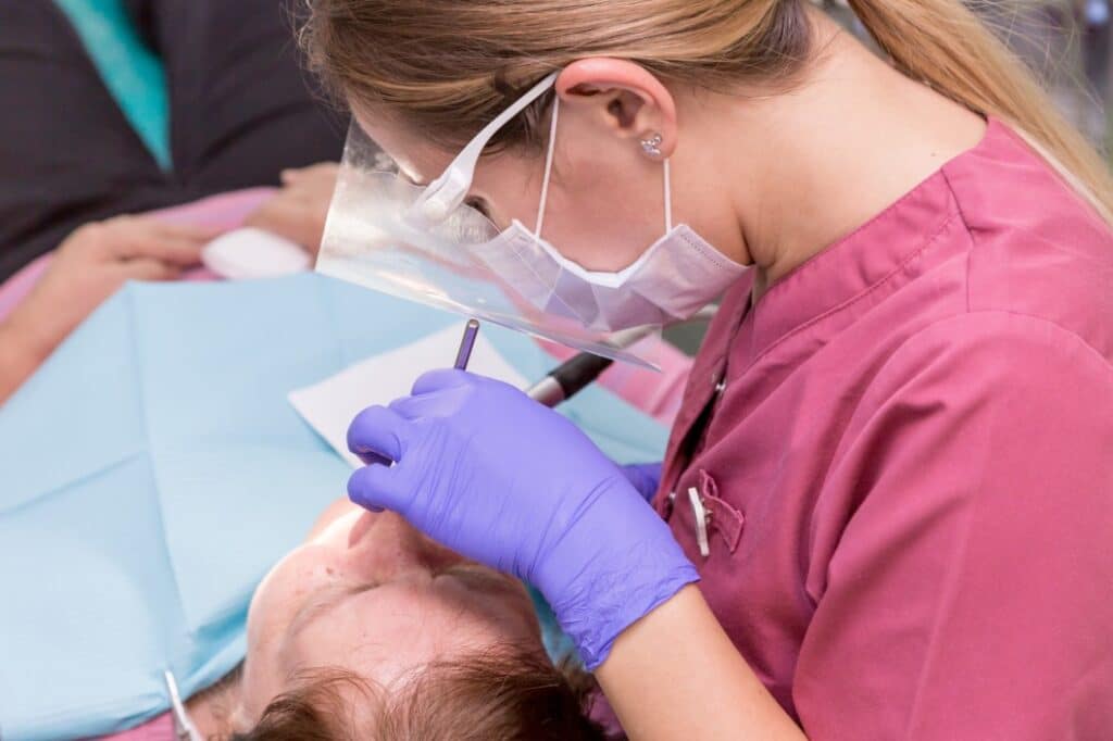 A dentist in Columbus, GA is cleaning a woman's teeth during a dental care session
