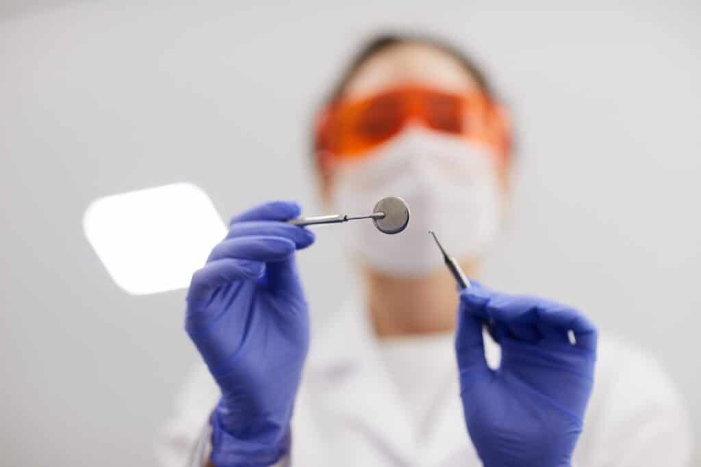 Female dentist holding instruments
