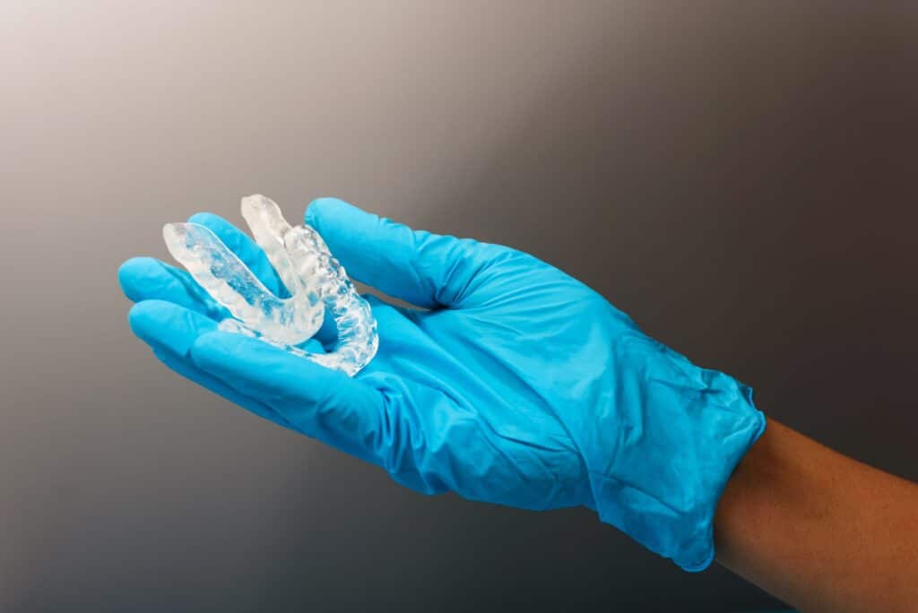Dentist doctor hand holding a dental aligner