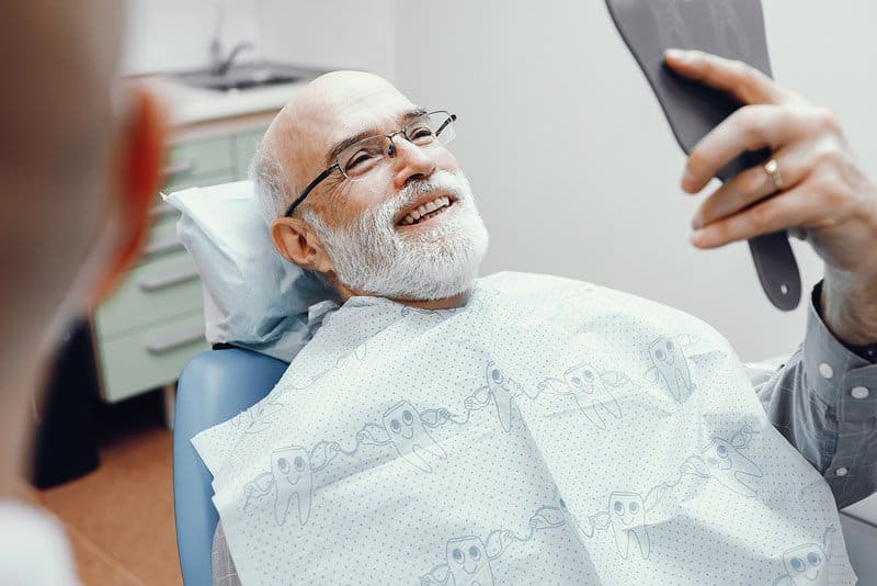 man sitting in a dentist chair smiling, Nitrous Oxide