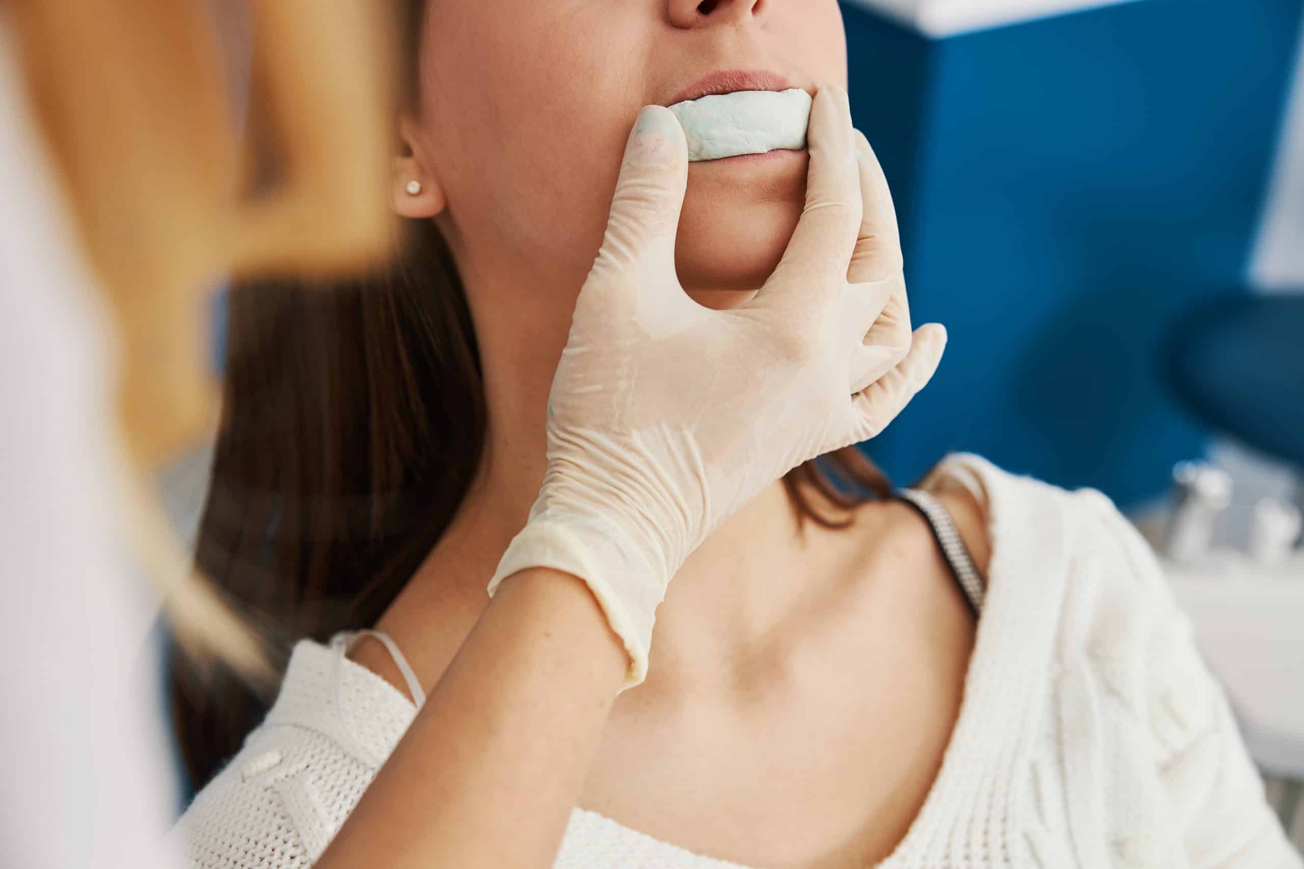 patient biting on cast mold of jaw held by dentis 2021 09 03 07 03 30 utc scaled 1, Nightguards