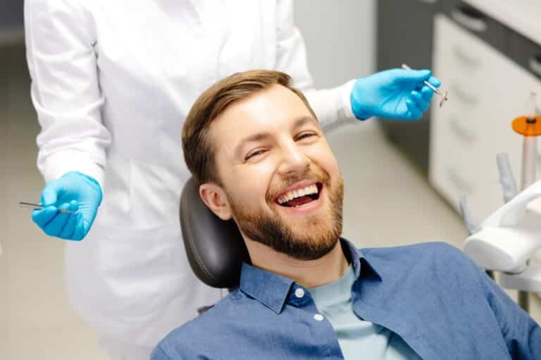 Man smiling at dentist office, teeth whitening