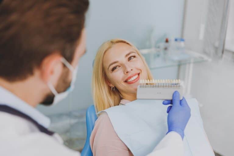 dentist shows a veneer enamel color palette to patient