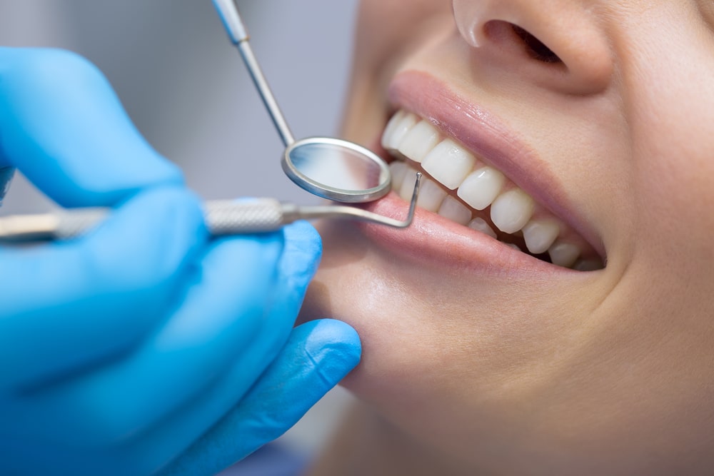 A closeup of a dentist examining their patient’s teeth