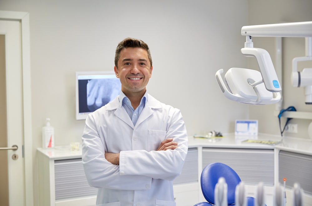 A smiling dentist in his office