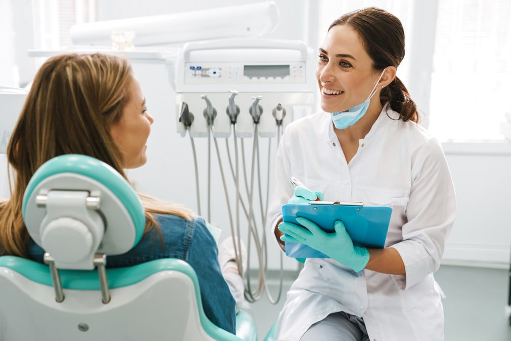 A dentist talking to her female patient in the dental office