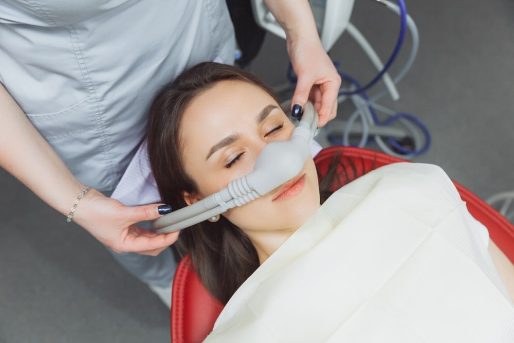 What is Conscious Sedation Dentistry? 2 A dentist putting an inhalation sedative mask on her female patient